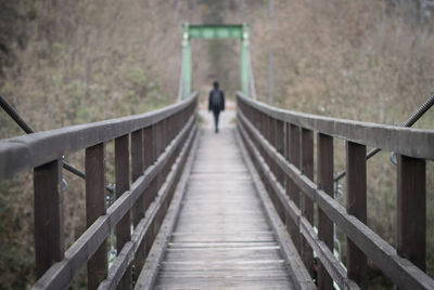 Rear view person on footbridge