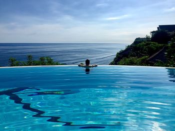 Man in swimming pool against sea