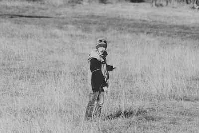 Portrait of cute boy standing on grassy field