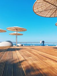 Umbrellas on beach against clear blue sky