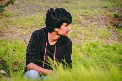 Young man looking away on field