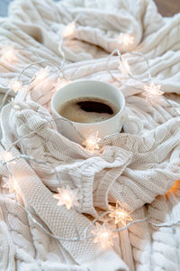 High angle view of coffee cup on bed