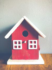 Close-up of red toy on wooden wall