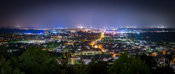 High angle view of city lit up at night