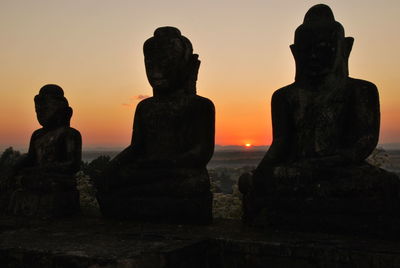 Silhouette of statues at sunset