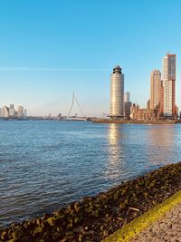 Scenic view of river by buildings against clear sky