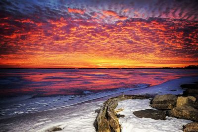 Scenic view of sea against dramatic sky during sunset