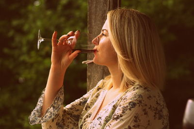 Full length portrait of a woman drinking glass