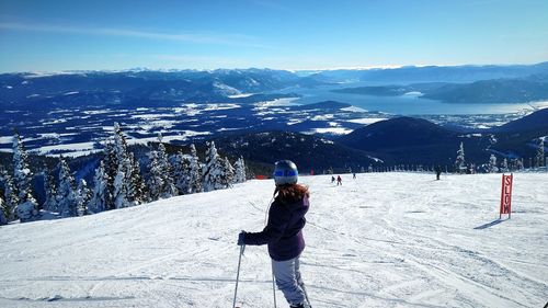 People skiing on snowcapped mountain against sky