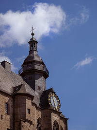 Low angle view of clock tower amidst buildings against sky