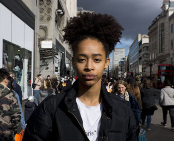 Portrait of young woman on street in city