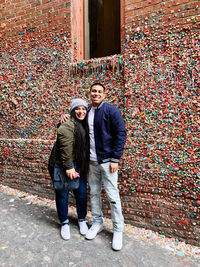 Full length portrait of young couple standing outdoors