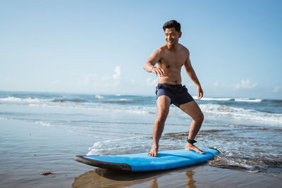 Rear view of shirtless man swimming in sea against sky