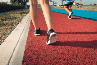 Low section of person walking on running track