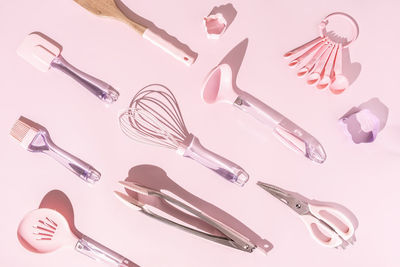 Pattern of mix pink kitchen utensils on light pastel pink background, flat lay, top view