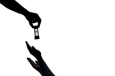 Silhouette person holding hands against white background