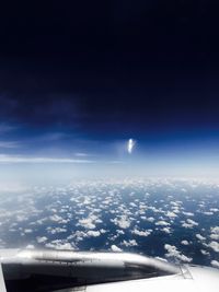 Airplane wing against sky at night