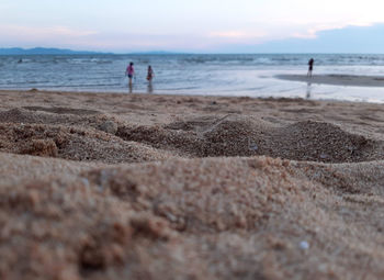 People on beach against sky