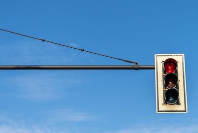 Low angle view of road signal against blue sky