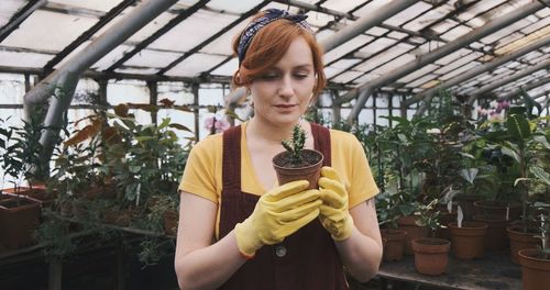 Portrait of young woman standing in greenhouse