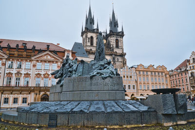 Statue amidst buildings against sky