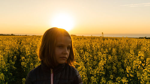 Portrait of woman on field against sky during sunset