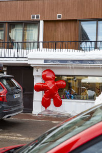 Red car on building in city