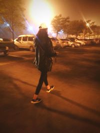 Rear view of woman walking on street at night