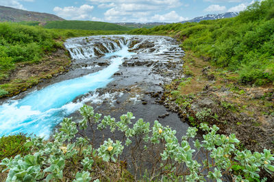 Scenic view of waterfall against sky