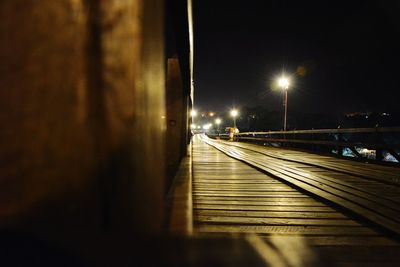 Illuminated railroad tracks in city at night