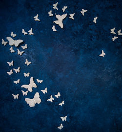 Full frame shot of blue background with artificial butterflies