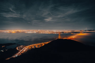 Illuminated bridge against sky at night