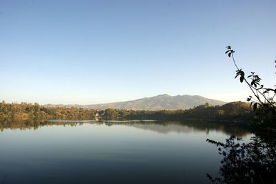 Scenic view of lake by mountains against clear sky