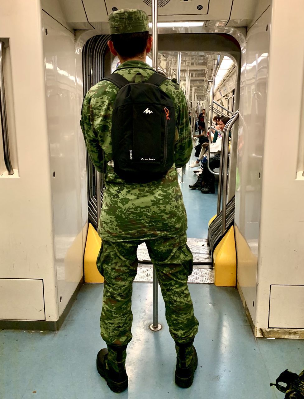 REAR VIEW OF PEOPLE STANDING IN TRAIN