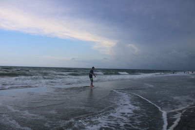 Man standing on beach against sky