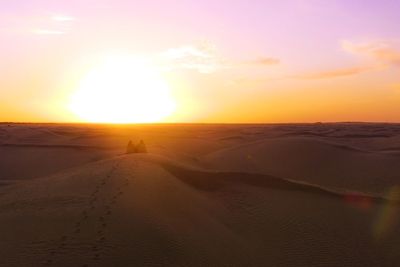 Scenic view of desert against sky during sunset