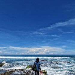 Man on beach against blue sky