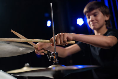 Midsection of man playing drum