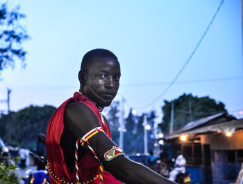 Young man wearing sunglasses against sky at night