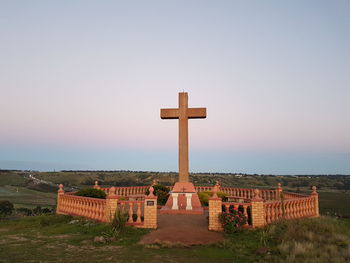 Cross on cemetery against clear sky