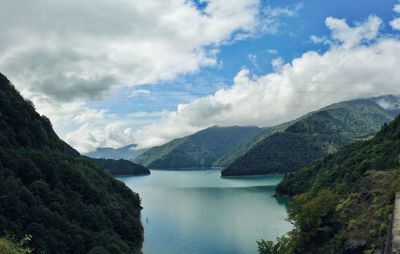 Scenic view of river and mountains against sky