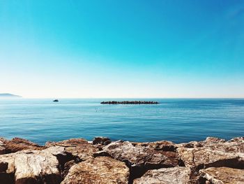 Scenic view of sea against clear blue sky