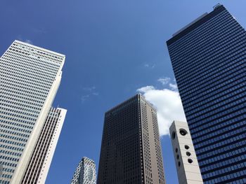 Low angle view of modern buildings against blue sky