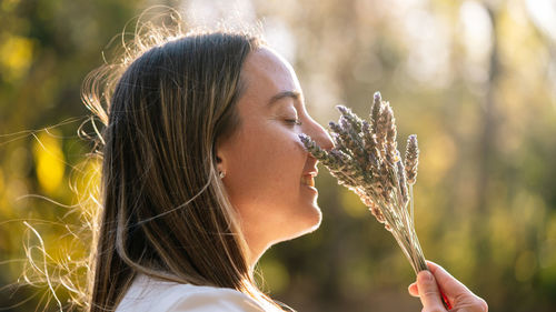 Close-up of young woman holding plant