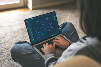 Midsection of woman using laptop at home
