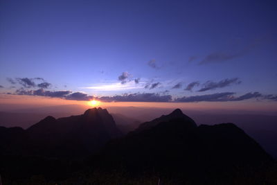 Scenic view of silhouette mountains against sky at sunset