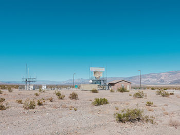 Lifeguard hut on land against clear blue sky