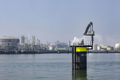 Commercial dock by sea against clear sky