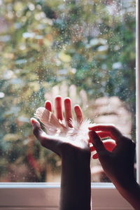 Close-up of cropped hand holding flower