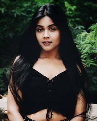 Close-up portrait of young woman standing against tree